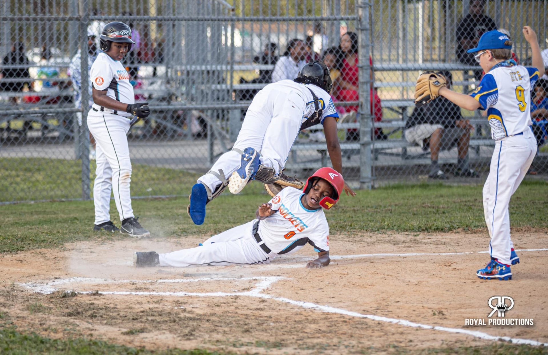Rockets player sliding home as catcher leaps